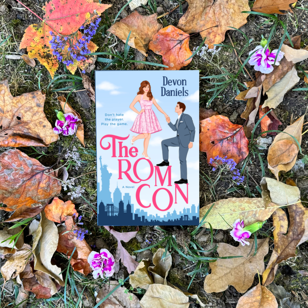 Photo of The Rom Con by Devon Daniels surrounded by leaves and flowers